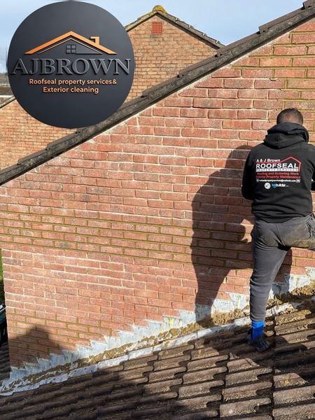 AJ Brown team member repointing brickwork and lead flashing on roof